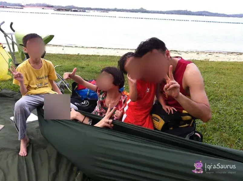 The family squeezed into one hammock on the grass by the sea