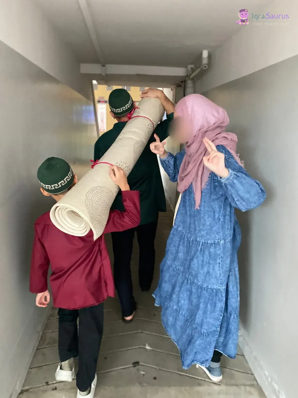 Three children carrying a rolled-up carpet down the corridor