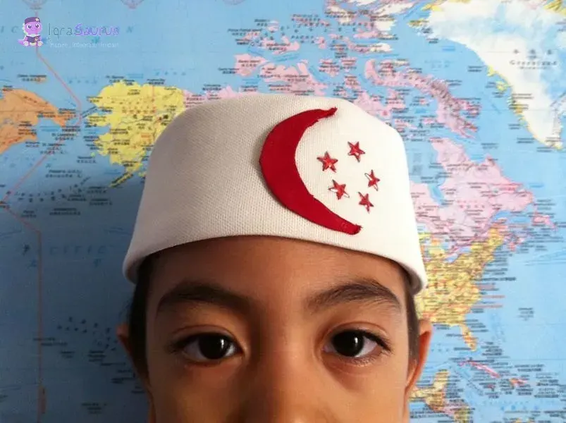 Syauqi in a white kopiah with the red crescent and five stars, a world map behind him