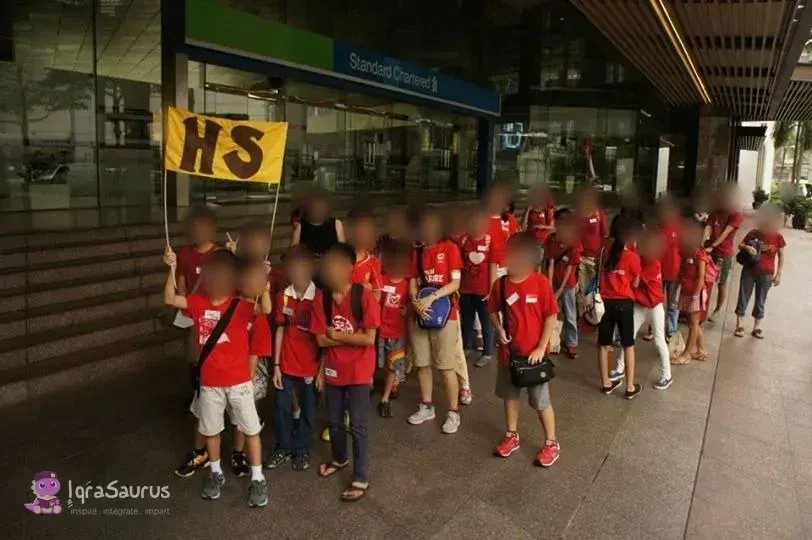 The homeschool group in red T-shirts behind a yellow "HS" banner, every face blurred